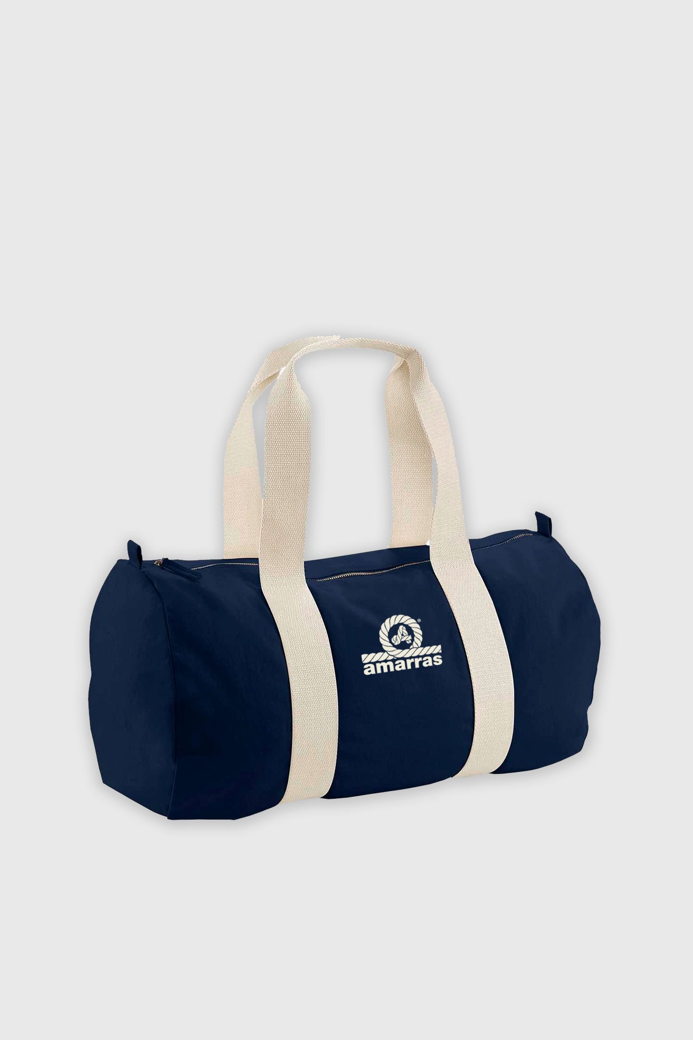 Bolsa tipo duffle de lona azul marino con asas de algodón crudo y logotipo clásico de Amarras, llevada por un modelo con sudadera roja.