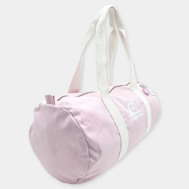 Bolsa duffle rosa de Amarras en vista lateral, con asas crudas, cierre de cremallera, logotipo blanco y chapa decorativa.
