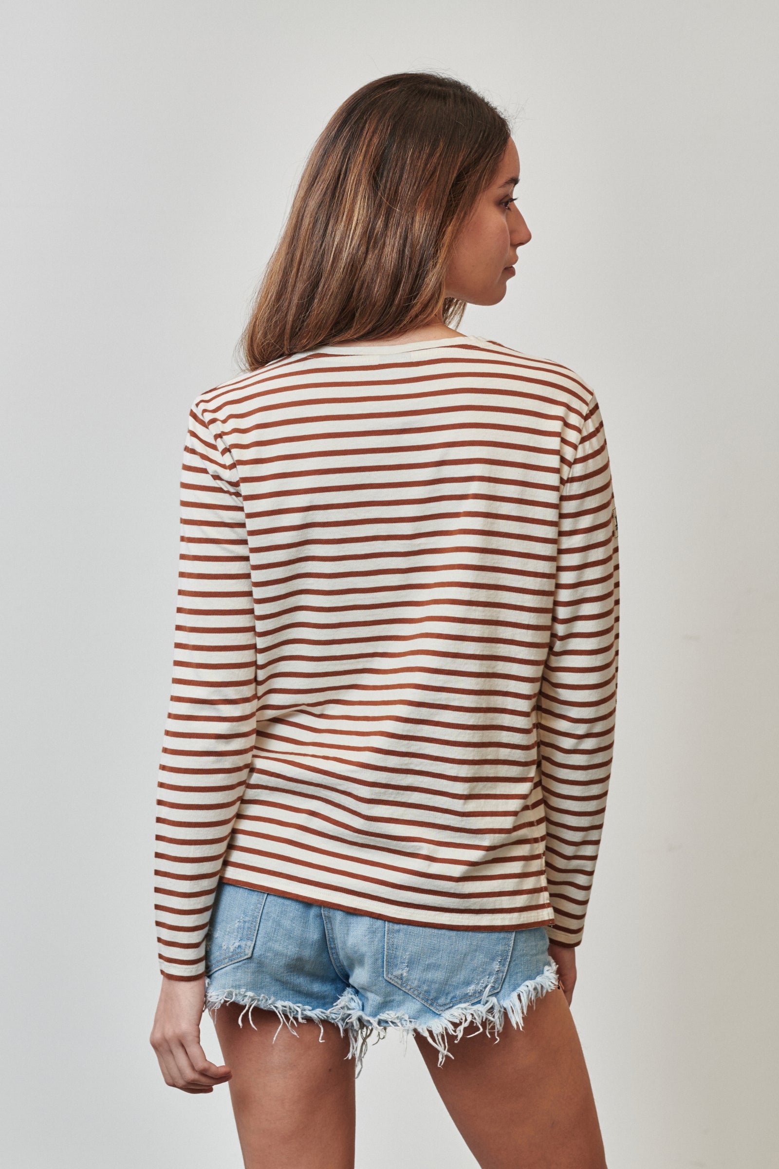 Vista trasera camiseta de manga larga modelo Riva para mujer de Amarras, con diseño de rayas marrones.