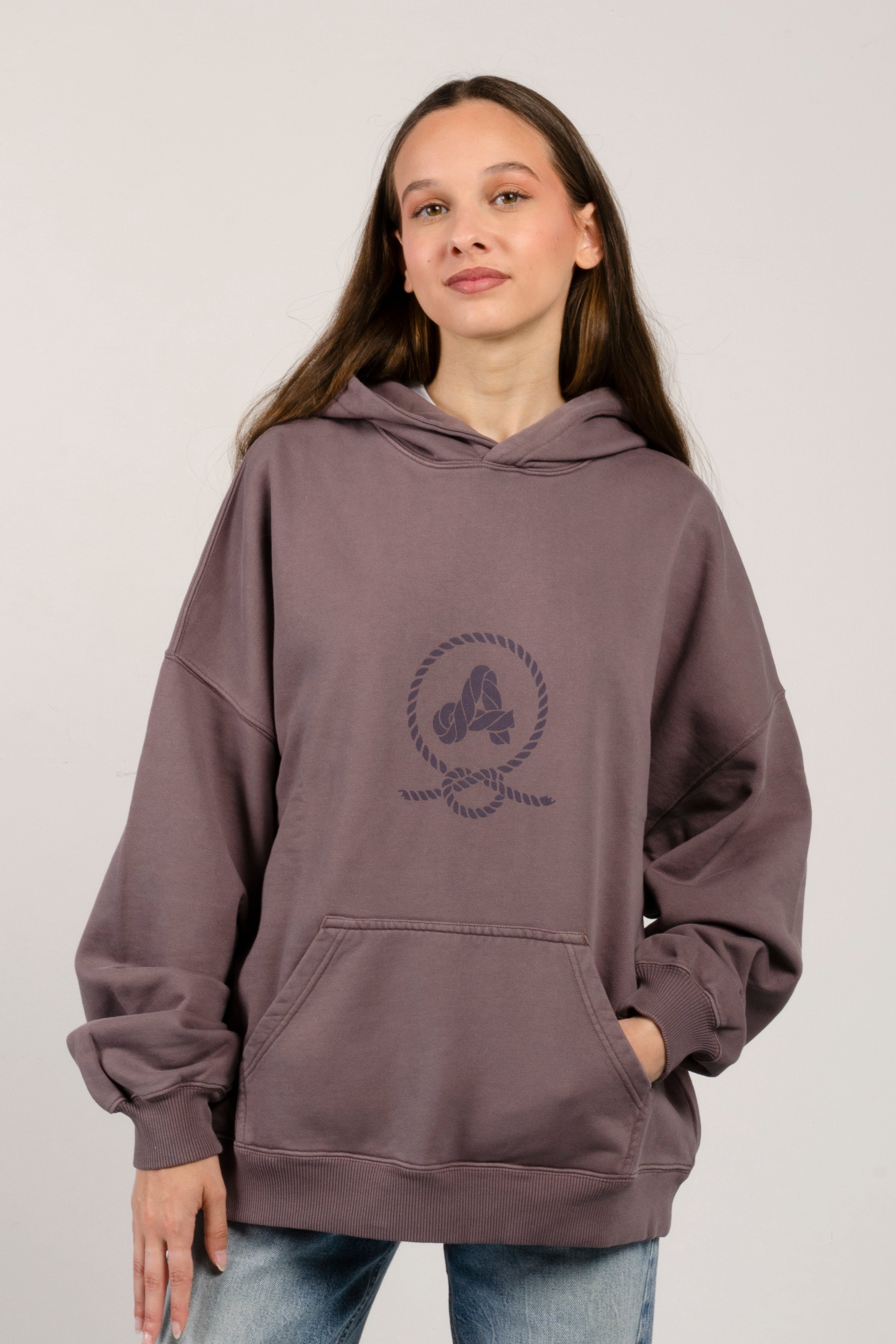 sudadera con capucha amarras lifestyle de mujer en color dusty purple y con serigrafia en pecho y espalda y corte boxy